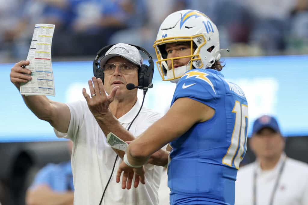 INGLEWOOD, CALIFORNIA - NOVEMBER 10: Head coach Jim Harbaugh of the Los Angeles Chargers talks to Justin Herbert #10 in the fourth quarter of a game against the Tennessee Titans at SoFi Stadium on November 10, 2024 in Inglewood, California.