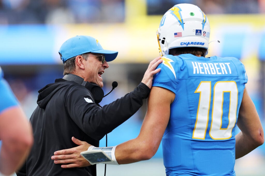 INGLEWOOD, CALIFORNIA - DECEMBER 15: Head coach Jim Harbaugh celebrates with Justin Herbert #10 of the Los Angeles Chargers after a touchdown in the first quarter against the Tampa Bay Buccaneers at SoFi Stadium on December 15, 2024 in Inglewood, California.