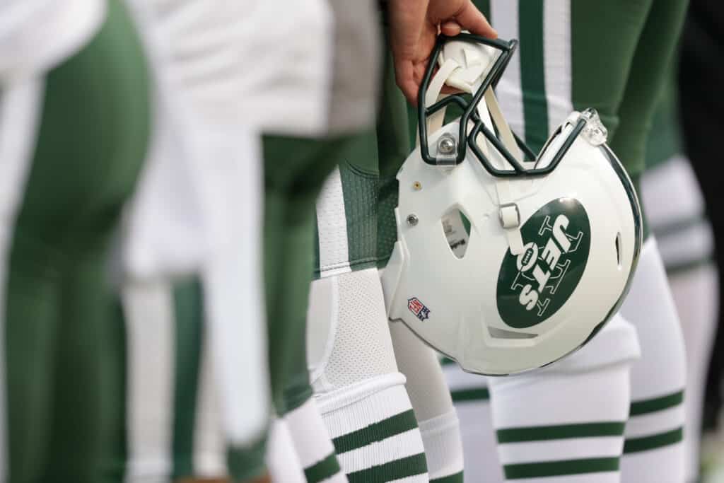 A New York Jets helmet is held behind a player's back during the national anthem before NFL action against the Kansas City Chiefs at Arrowhead Stadium before the game on September 25, 2016 in Kansas City, Missouri.