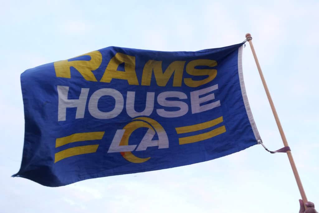 HERMOSA BEACH, CALIFORNIA - APRIL 25: A fan holds up a flag that reads "Rams House" during the Los Angeles Rams Draft Experience presented by SoFi on April 25, 2024 in Hermosa Beach, California.