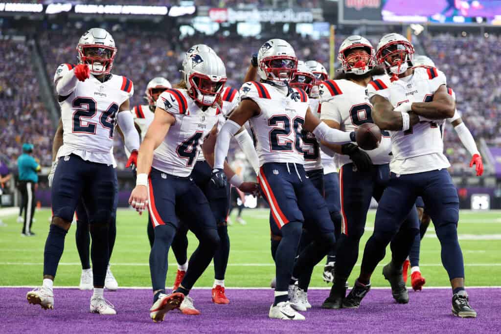 MINNEAPOLIS, MINNESOTA - AUGUST 16: Alex Austin #28 of the New England Patriots (C) celebrates his interception against the Minnesota Vikings with teammates in the first quarter during the NFL Preseason 2025 game between New England Patriots and Minnesota Vikings at U.S. Bank Stadium on August 16, 2025 in Minneapolis, Minnesota.