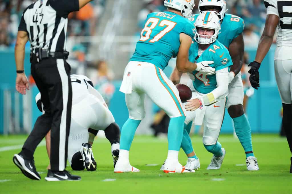 MIAMI GARDENS, FLORIDA - AUGUST 23: Quinn Ewers #14 of the Miami Dolphins is helped up after being sacked Danny Striggow #92 of the Jacksonville Jaguars during the third quarter of a NFL Preseason 2025 game between Jacksonville Jaguars and Miami Dolphins at Hard Rock Stadium on August 23, 2025 in Miami Gardens, Florida.