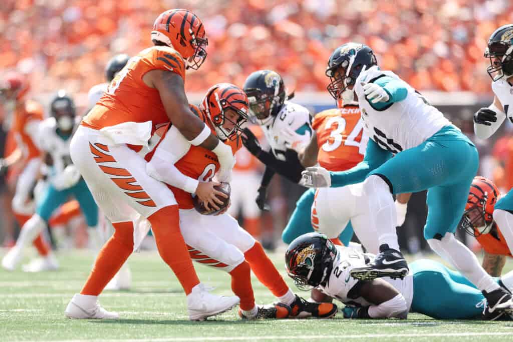 CINCINNATI, OHIO - SEPTEMBER 14: Joe Burrow #9 of the Cincinnati Bengals is sacked in the first quarter of the game by Foyesade Oluokun #23 of the Jacksonville Jaguars at Paycor Stadium on September 14, 2025 in Cincinnati, Ohio.